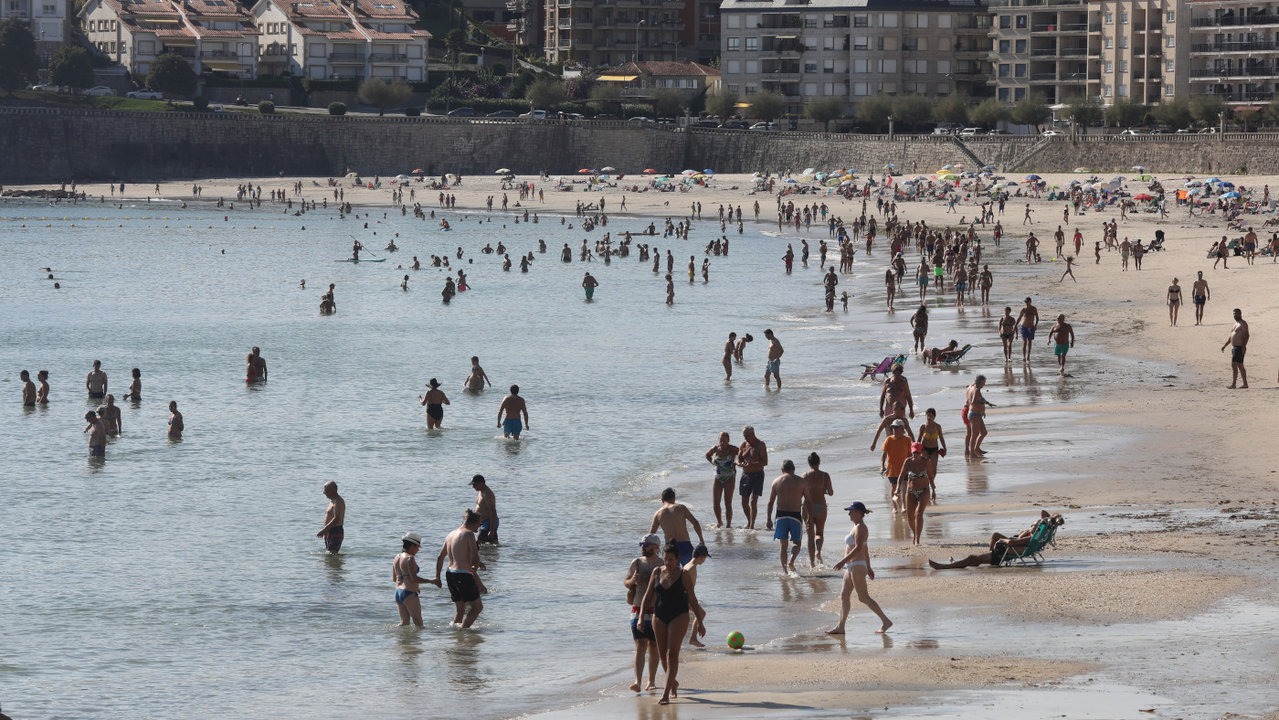 <p> Aspecto que presentaba este domingo la playa de Silgar, en Sanxenxo, con numerosos bañistas. DAVID FREIRE </p>