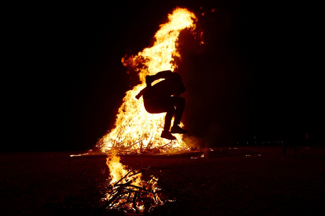 Una persona salta la hoguera en una imagen de archivo de la noche de San Xoán. GONZALO GARCÍA