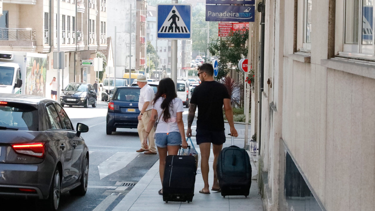 Turistas con maletas en Sanxenxo. JOSÉ LUIZ OUBIÑA