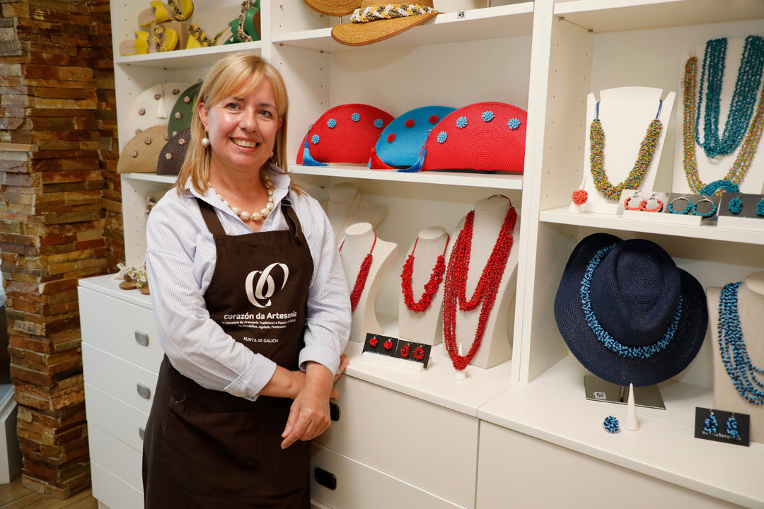 Montse Betanzos na súa tenda amosando os produtos que crea a partir de cunchas do mar
a múltiples obxectos dende os tradicionais colares ata sombreiros, zapatos e bolsos. J.OUBIÑA