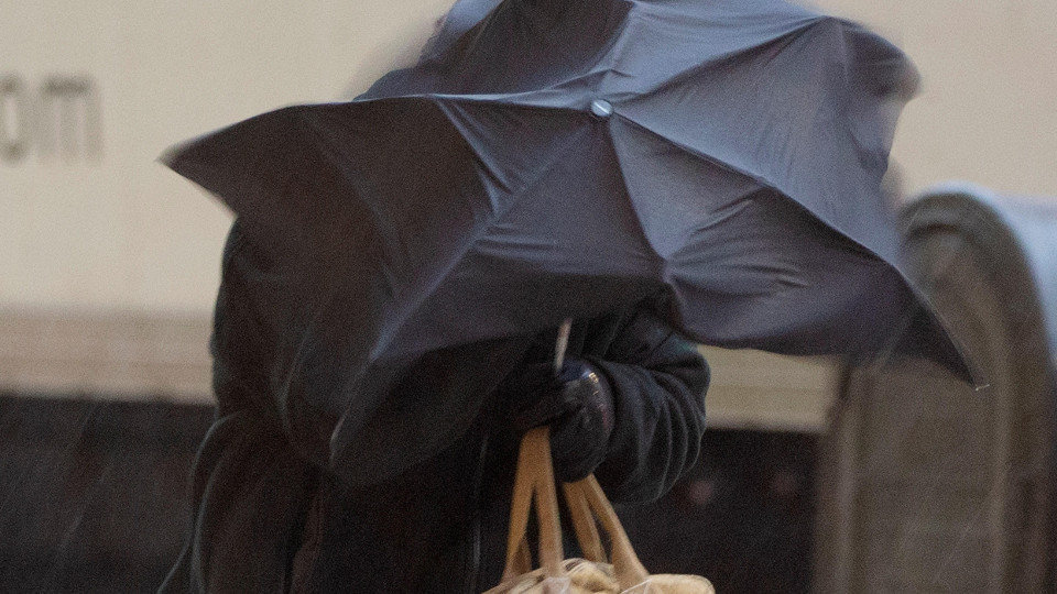  Una persona se cubre con un paraguas en pleno temporal de viento y lluvia. ADP 