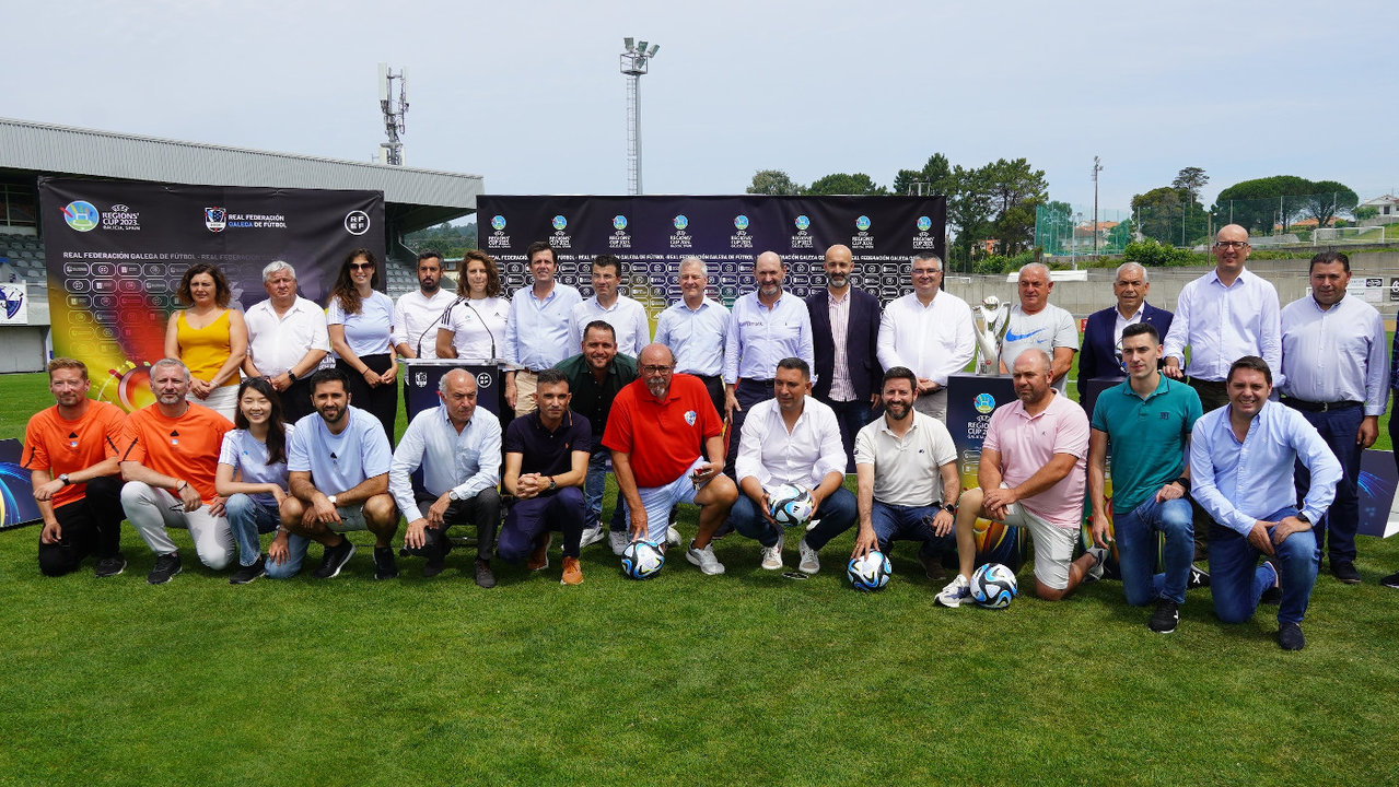 Miembros de la UEFA y la RFGF, alcaldes, concejales y otros miembros de la organización posan con el trofeo durante la presentación de la Copa de las Regiones. RFGF