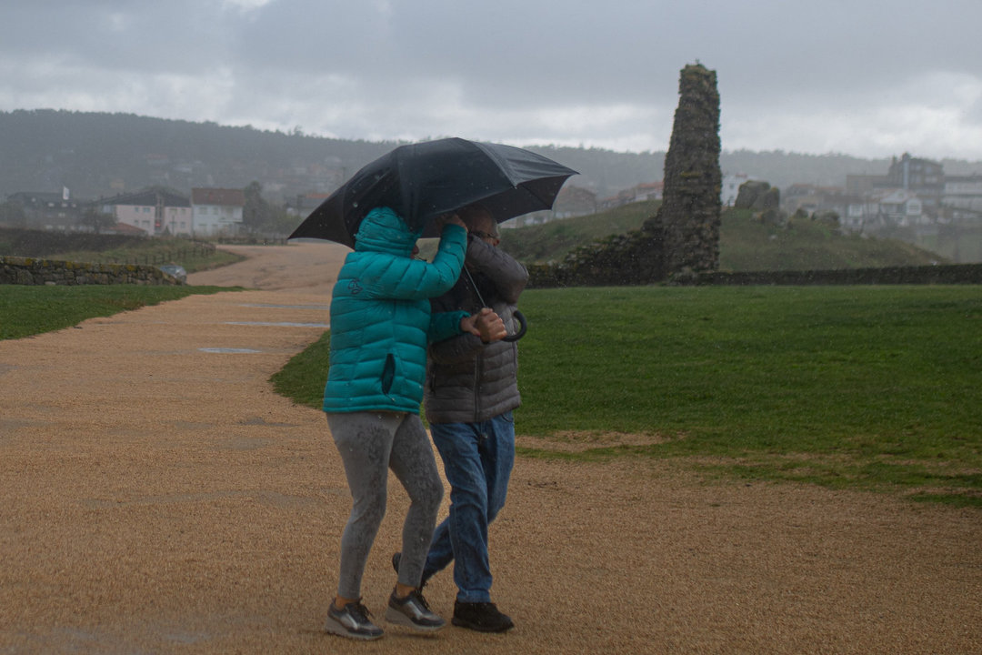 Una pareja pasea este domingo en las inmediaciones de A Lanzada, donde se registraron rachas de viento de 85 km/hora. ELENA FERNÁNDEZ | EUROPA PRESS