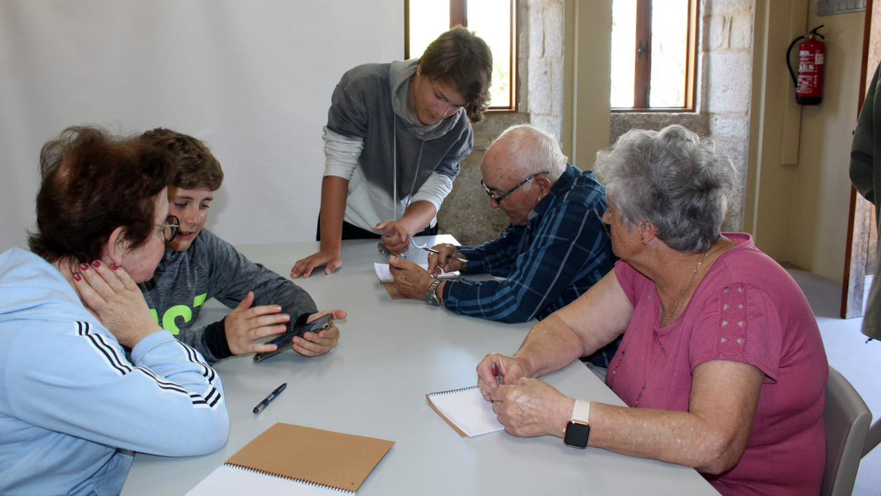 En el taller 'Nas túas mans' jóvenes voluntarios enseñan a usar las tecnologías a los mayores. DS