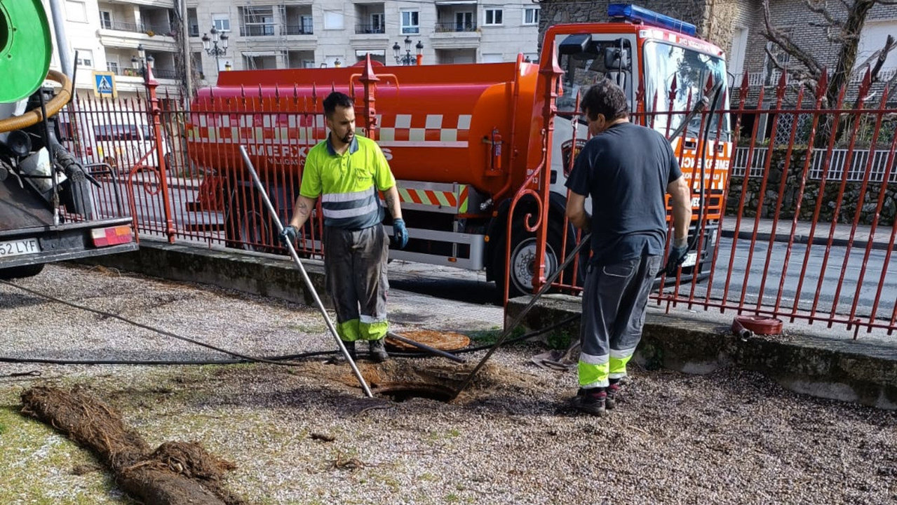 Operarios municipales de Vilagarcía en el parque Compostela trabajando en la retirada de las raíces que obturaban la canalización. DS