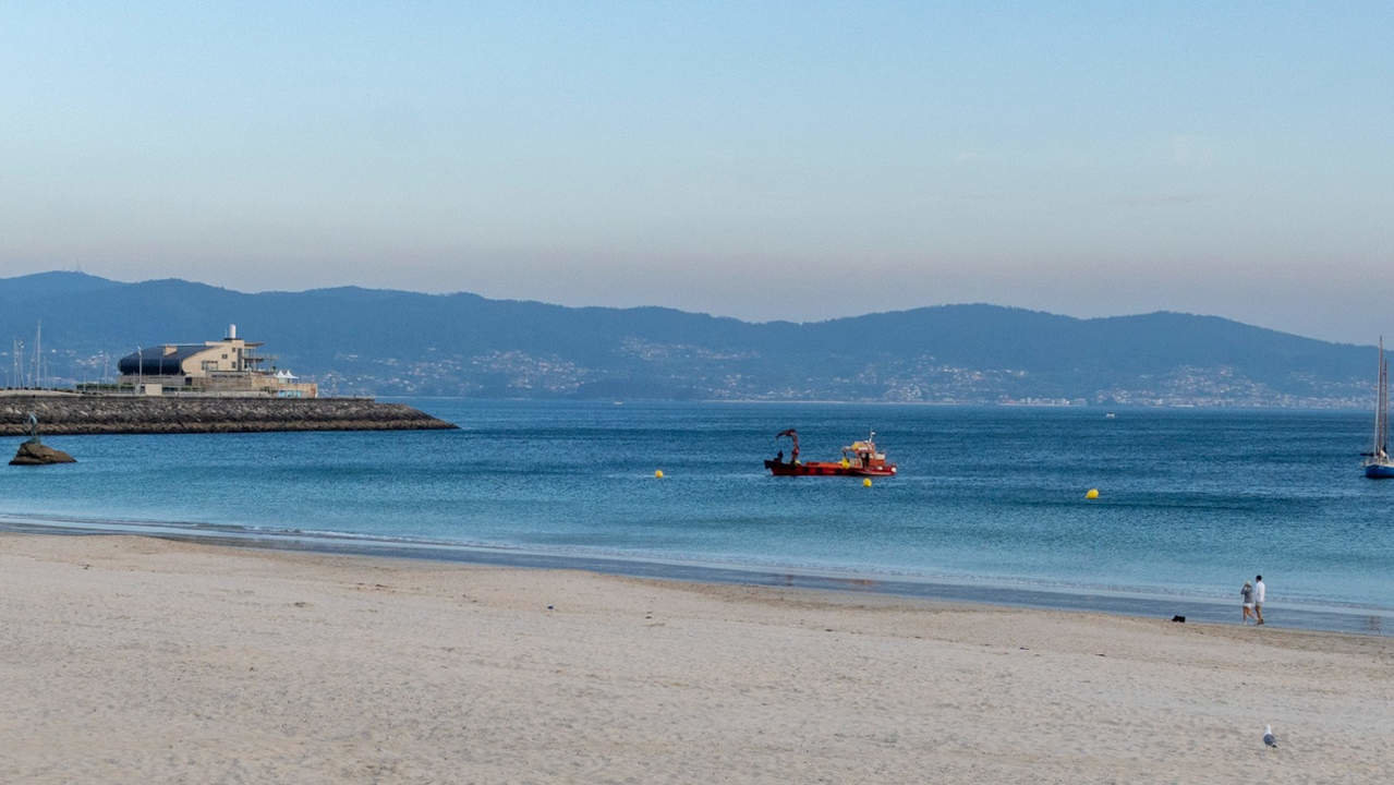 Una embarcación participó en los trabajos de colocación de balizas en la playa de Silgar este viernes por la tarde. DS